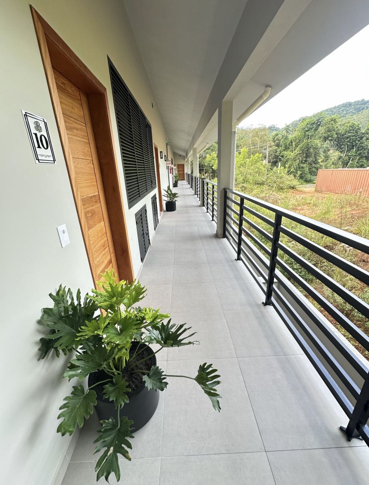 Corredor com guarda-corpo e vista para o verde