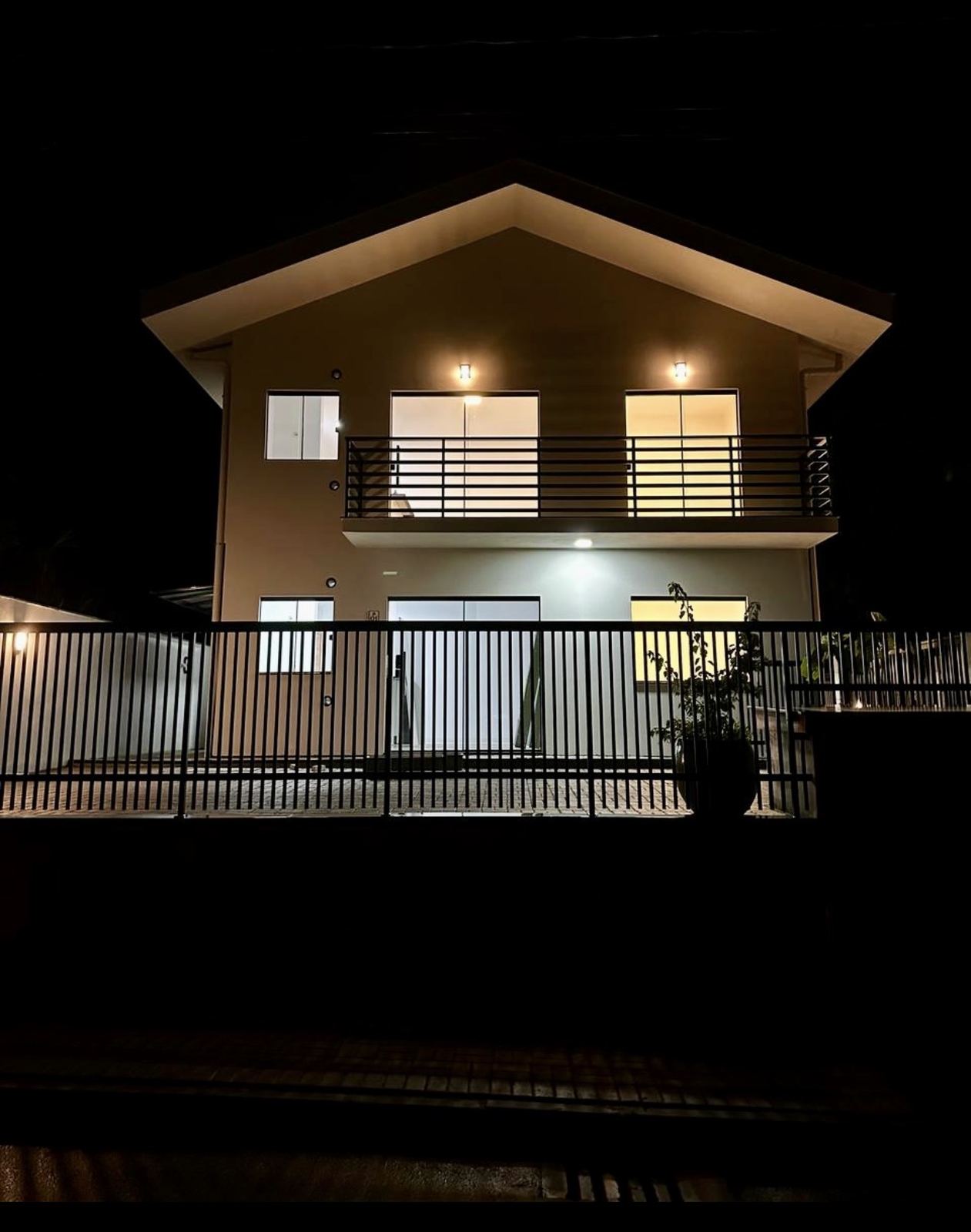Fachada do Residencial Arno Behling à noite, com a sacada iluminada