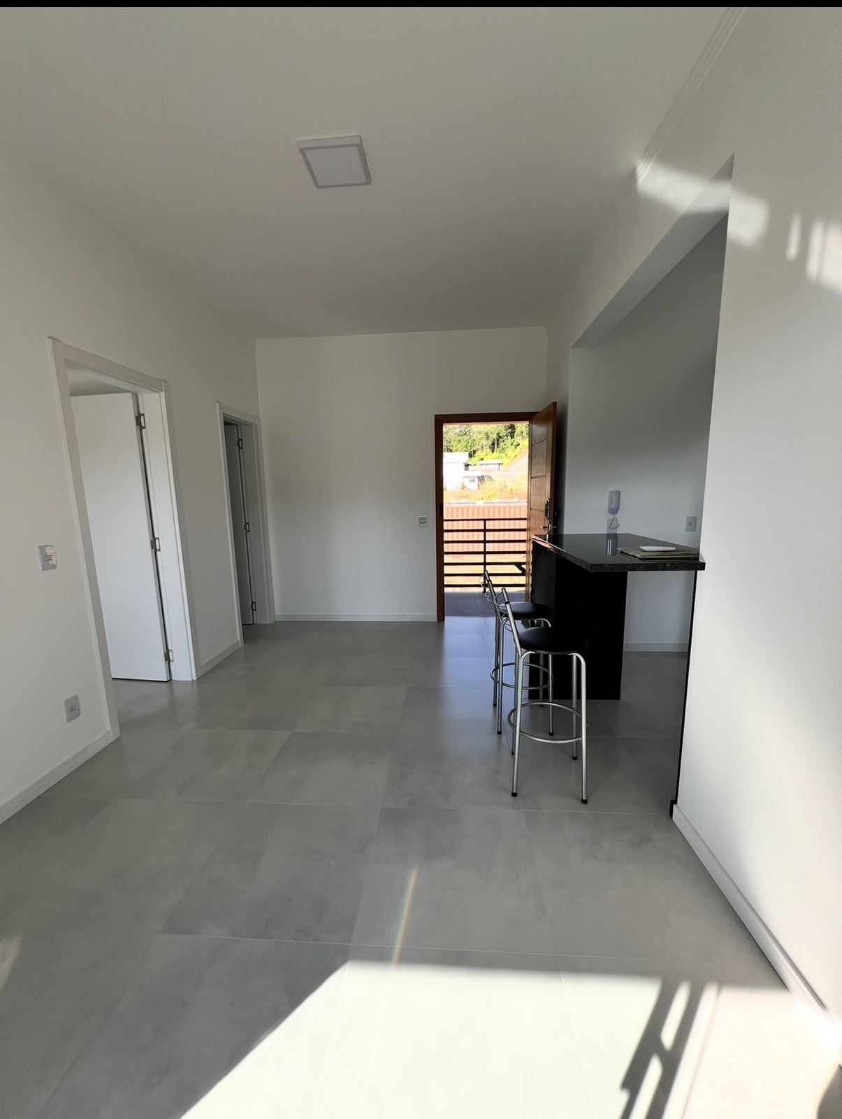 Sala integrada à cozinha, com bancada em granito