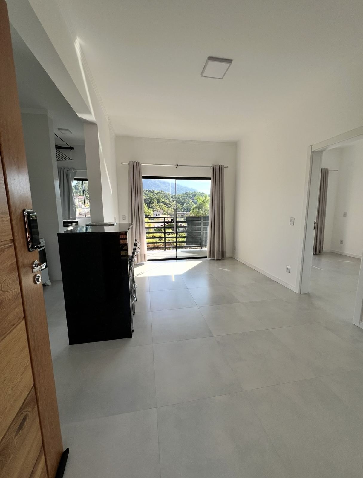 Sala vista da porta de entrada, com piso em porcelanato