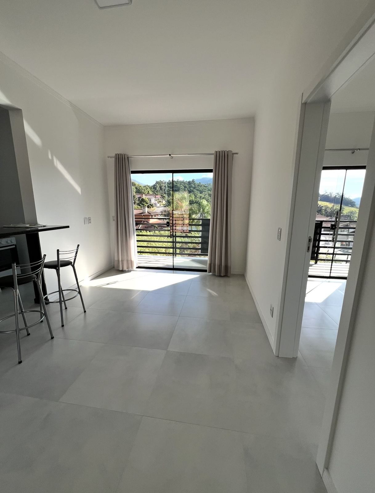 Sala com acesso à sacada e cortinas